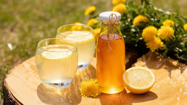 Pampeliškový sirup v lahvičce s nápojem a květy