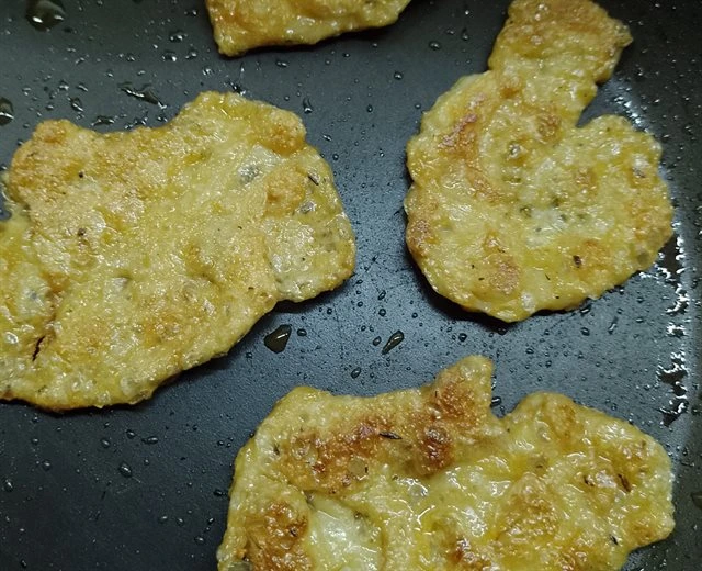 Zlatohnědé smažené kousky seitanu na pánvi.