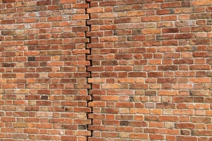 Dilatační spára v cihlové zdi s viditelnou švovou linií.
