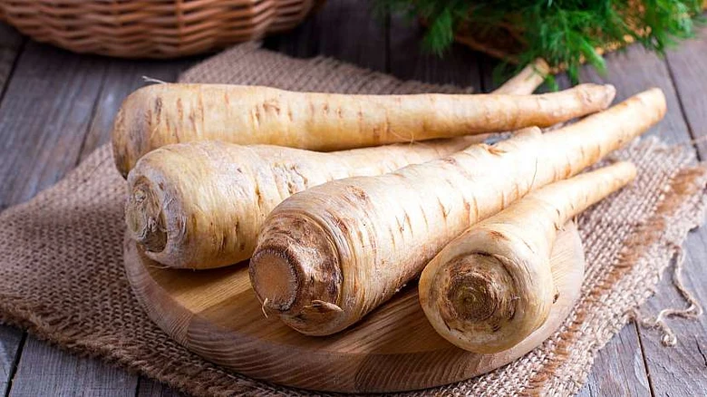 Čerstvé pastiňáky na dřevěném talíři s kořením