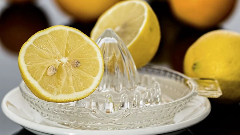 Poloviční citron na skleněném výtisku s dalšími citróny