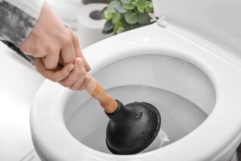 Osoba čistí záchod kbelíkem