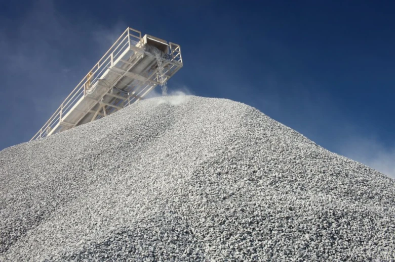 Hromada štěrku na stavbě, výrobní pás přesypává materiál