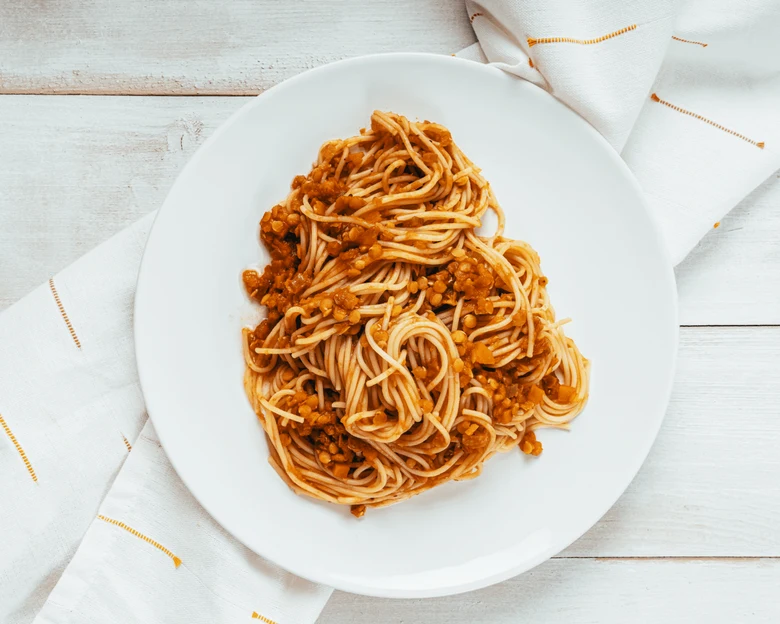 Pasta s rajčatovou omáčkou na bílém talíři.