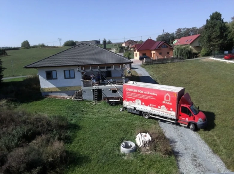 Dům během izolace, pracovníci na balkóně, dodávkový vůz s nápisem o izolaci