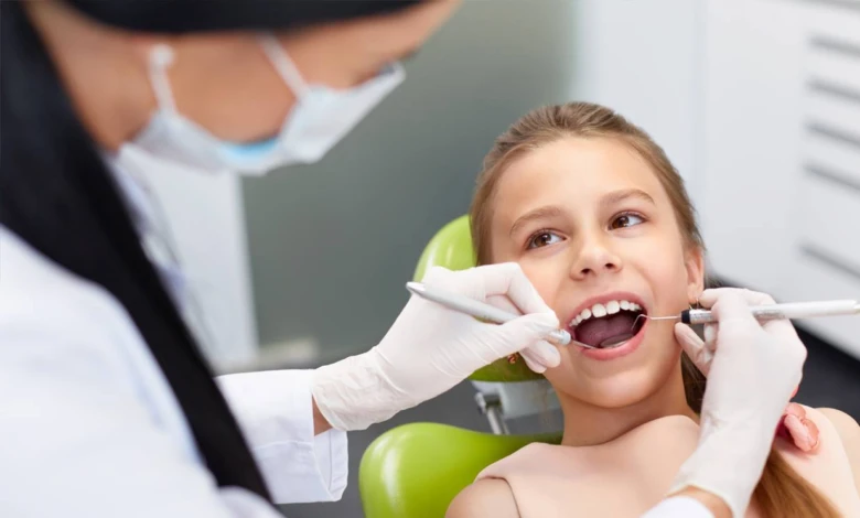 Dentista vyšetřuje zuby dítěte v ordinaci