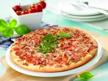 Pečená pizza s šunkou, sýrem a bazalkou na dřevěném podkladu