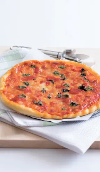 Dokonale pečená pizza s sýrem a bazalkou na dřevěné desce