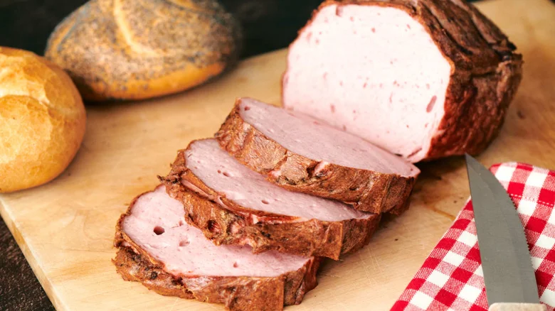 Nakrájené bavorské sekaná s chlebem na dřevěném prknu.