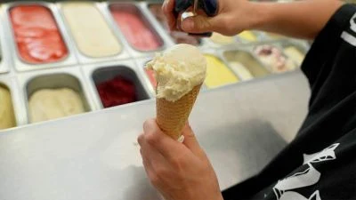 Domácí zmrzina se lžící do kuželku, barevné chutě v mrazáku.