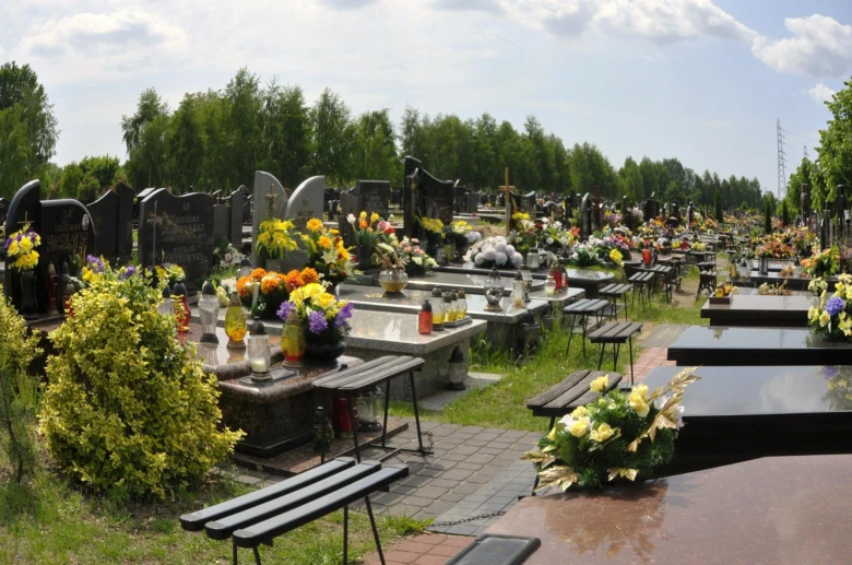 Hřbitov s hroby ozdobenými květinami a svíčkami