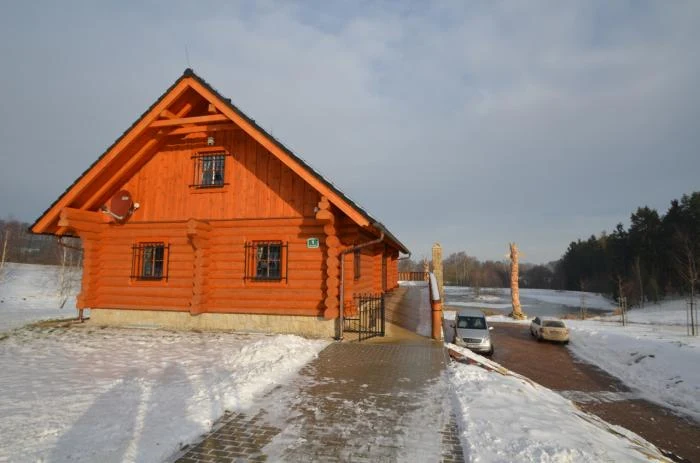 Tradiční dřevěný dům v zimním prostředí s sněhem kolem.
