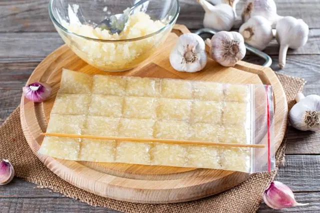 Zamražený česnek v sáčku na dřevěné desce