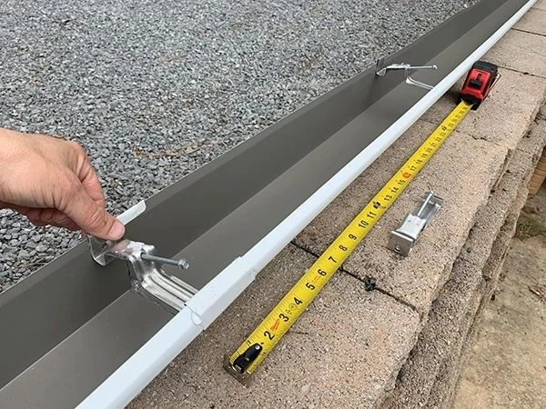 Instalace okapového držáku pomocí šroubováku a měřítka
