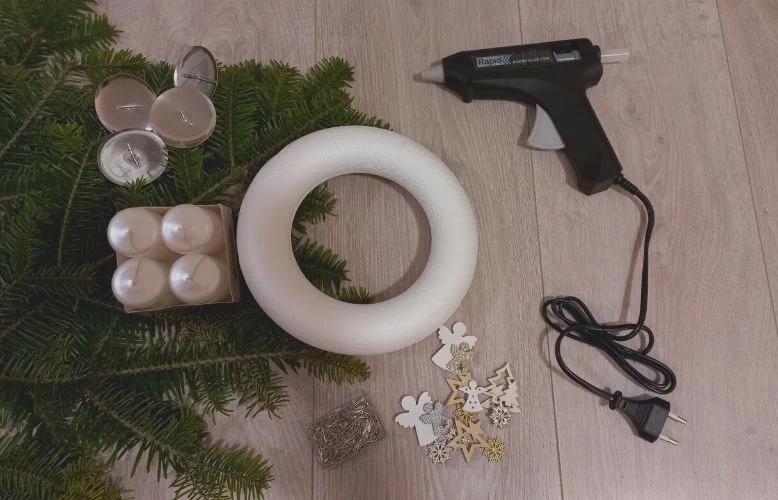 Materiály pro výrobu netradičního adventního věnku: pěnový kroužek, jehličí, svíčky, dekorace a lepicí pistole