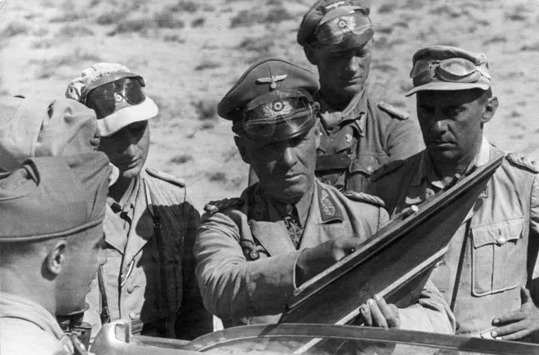 Němečtí důstojníci v pouštních uniformách studují mapu.