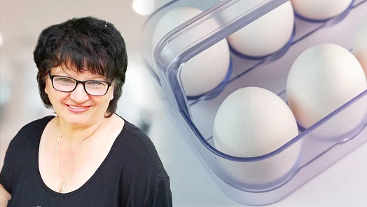 Žena vedle vajec uložených v chladničce
