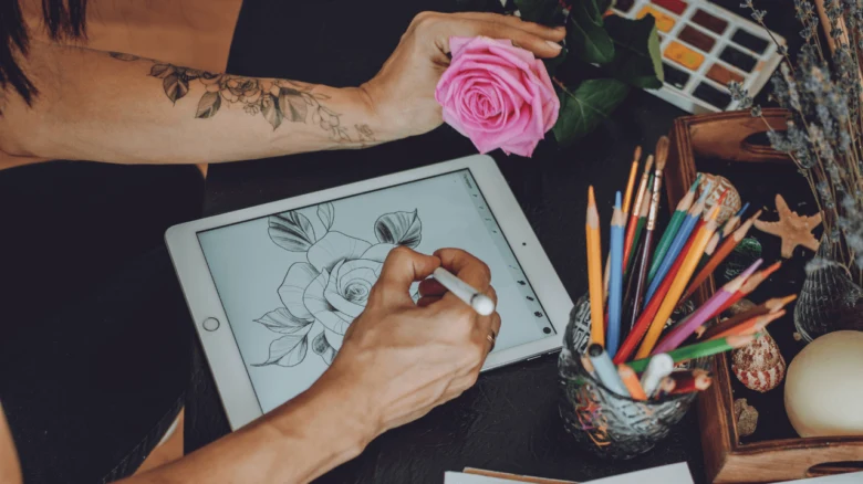 Žena kreslí růži na digitálním tabletu s tužkou