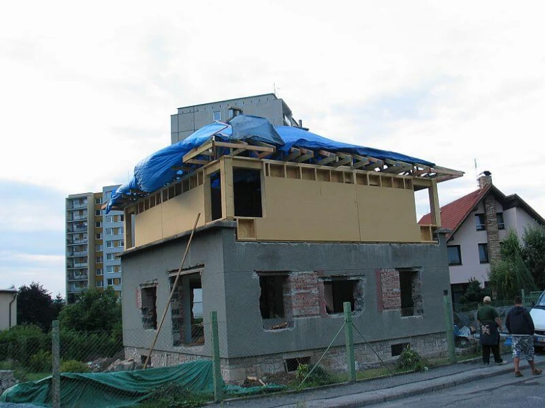 Přístavba k domu v průběhu, dřevěná konstrukce a modrý plachet