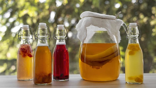 Různé druhy domácího kombucha v skleněných lahvích a džbánu