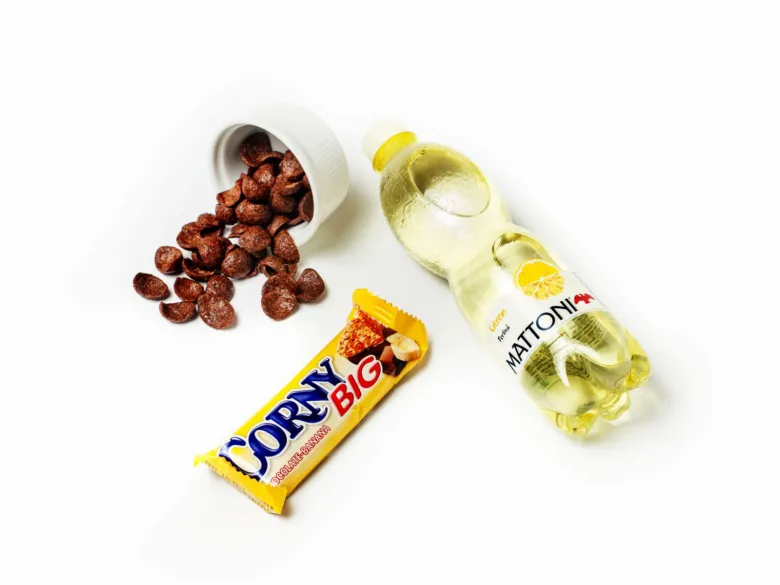 Sladké potraviny: čokoládové cereálie, tyčinka Corny Big a limetková soda