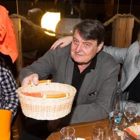 Artur Štaidl drží košík s chlebem během večeře
