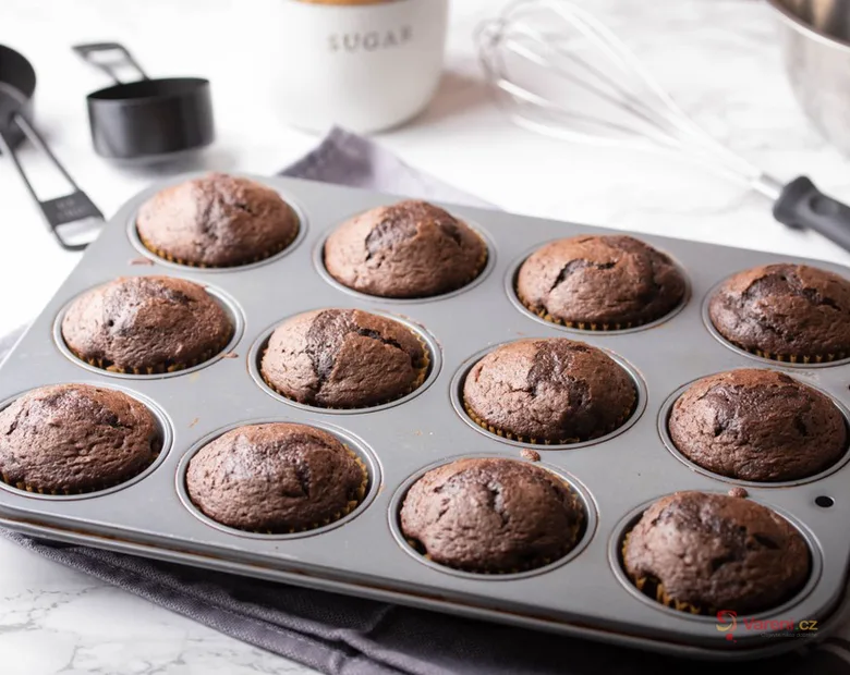 Čerstvé čokoládové kefírové muffiny v pekáči po vyjmutí z trouby.