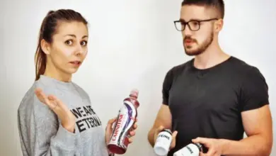 Muž a žena drží lahve s doplňky stravy pro spalování tuků.