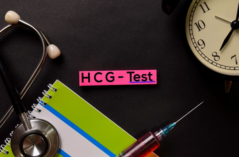 Stetoskop, špička s hCG testem na černém pozadí.