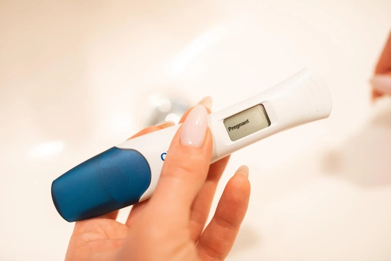 Digitální těhotenský test ukazující výsledek v koupelně.