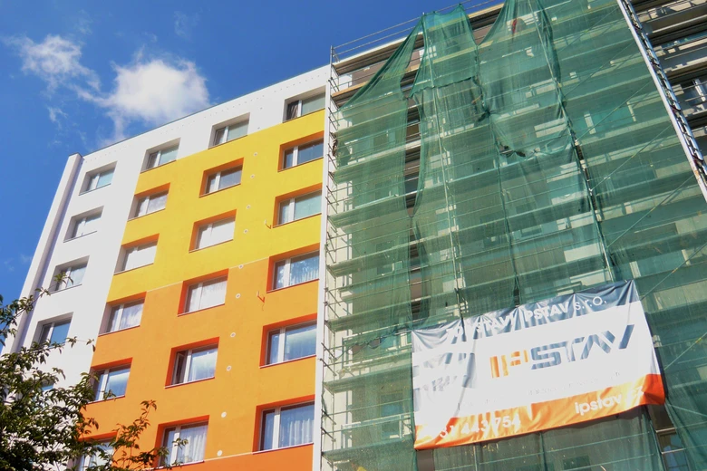 Bytový dům v revitalizaci s opěrnou konstrukcí na fasádě.