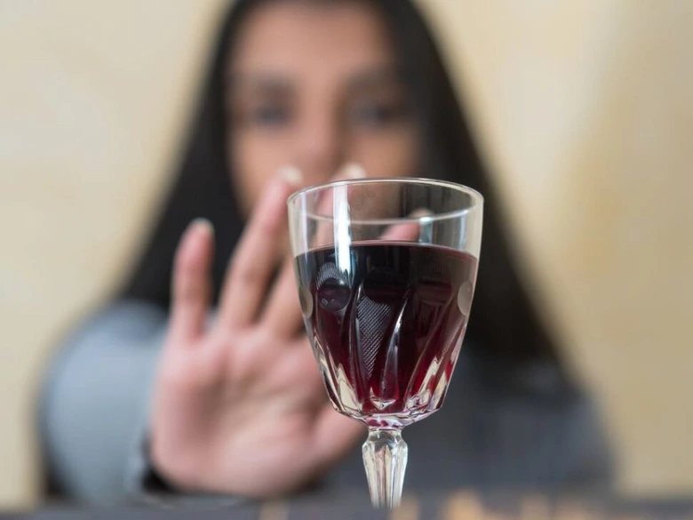 Žena odmítá skleničku vína gesto ruky.