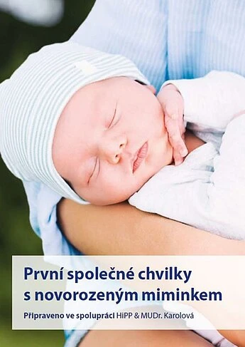 Spící novorozené miminko v náručí dospělého.