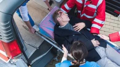 Záchranáři nosí zraněného pacienta do sanitky.