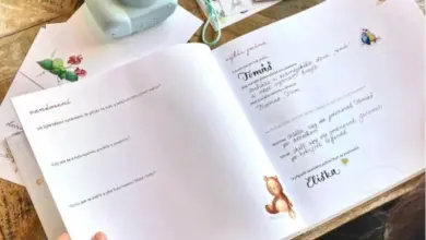 Otevírání knihy s výběrem jmen pro děti vedle fotoaparátu.
