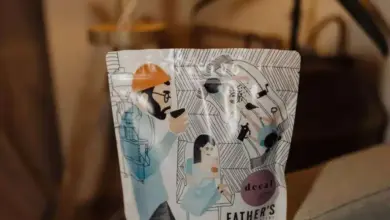 Sáček bezkofeinové kávy značky Father’s na šedé ploše.