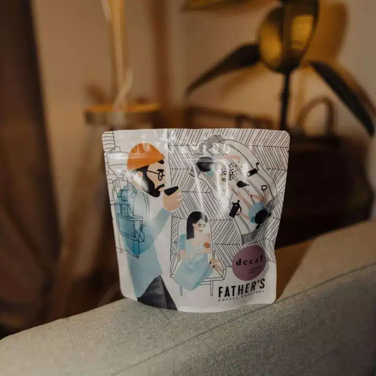Sáček bezkofeinové kávy značky Father’s na šedé ploše.