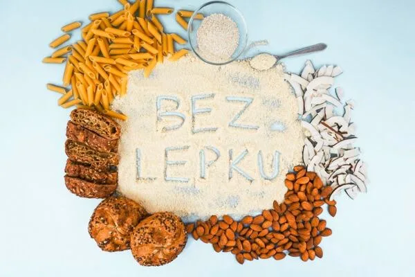Různé bezlepkové potraviny jako těstoviny, ořechy a mouka s nápisem BEZ LEPKU.