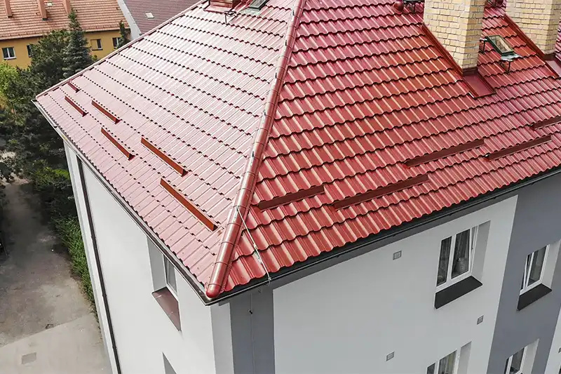 Nová červená střecha po revitalizaci bytového domu