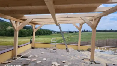 Stavba dřevěného altánu na zahradě s výhledem do krajiny.
