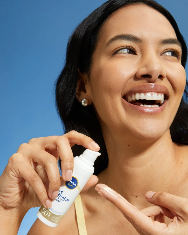 Žena drží lahvičku s opalovacím krémem SPF50+