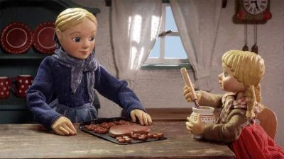 Děti připravují vánoční cukroví s džemem v kuchyni.