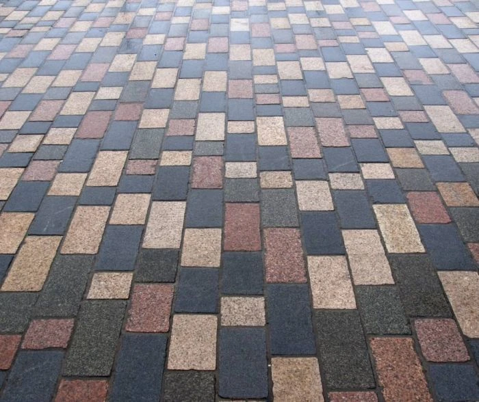 Hotový povrch z barevných zámkových dlažebnic položených v pravidelném vzoru.