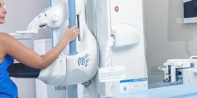 Žena upravuje lékařský přístroj pro diagnostiku nádorů.