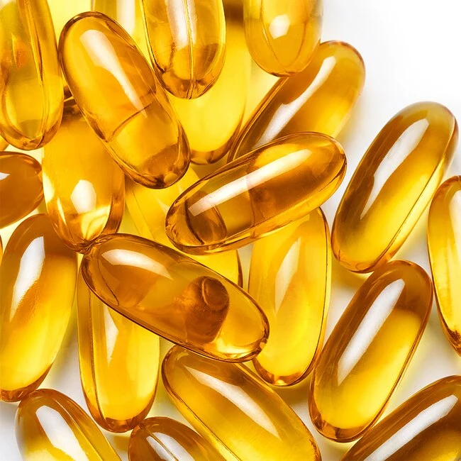 Zlaté průsvitné kapsle s omega-3 mastnými kyselinami.