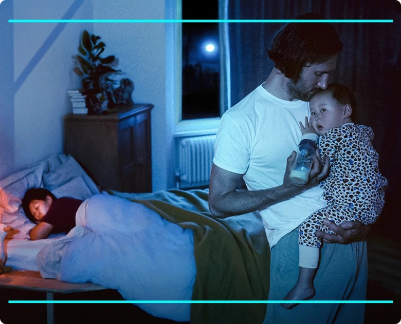 Father feeding baby at night