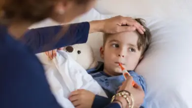 Dětský pacient s teploměrem v posteli, péče o subfebrilii