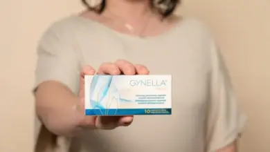Žena drží krabičku s doplňkem pro vaginální zdraví značky Gynella.