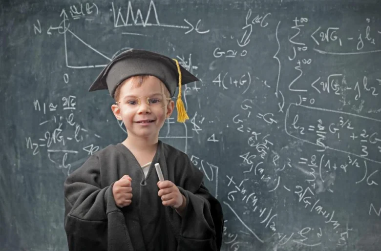 Dětský student v šatě s tabulí plnou matematických rovnic.