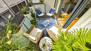 Balkon s různými rostlinami v květináčích a židlí.